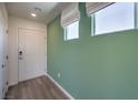 Light-filled entryway with green accent wall and wood floors at 2645 Snapdragon Falls Ave # 107, North Las Vegas, NV 89081