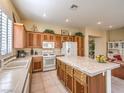 Bright kitchen with an island, white appliances, and wood cabinets at 30 Fountainhead Cir, Henderson, NV 89052