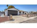 Front view of house, showing dark brown garage door and a black metal fence at 4111 E Saint Louis Ave, Las Vegas, NV 89104