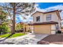 Two-story house with a tan facade, red roof, and a landscaped front yard at 5213 Tamanar Dr, Las Vegas, NV 89130