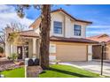 Two-story house with a tan facade, red roof, and a landscaped front yard at 5213 Tamanar Dr, Las Vegas, NV 89130