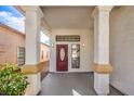 Red front door with oval window and a covered porch at 5213 Tamanar Dr, Las Vegas, NV 89130