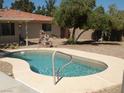 Kidney-shaped swimming pool with a concrete deck at 7315 Racel St, Las Vegas, NV 89131