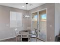 Small dining area with white table and chairs near sliding door at 10122 Ashford Mill Ct, Las Vegas, NV 89178
