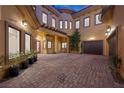 Expansive brick courtyard with direct garage access, multiple windows and entry points, plus lush landscaping at 10923 Willow Heights Dr, Las Vegas, NV 89135