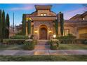 Grand entrance showcasing a stone archway, lush landscaping, and a custom wood door at 10923 Willow Heights Dr, Las Vegas, NV 89135