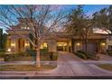 Stunning home with a porte-cochere, lush landscaping, and a beautiful facade with stone accents at 10923 Willow Heights Dr, Las Vegas, NV 89135