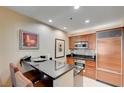 Modern kitchenette featuring granite countertops, wooden cabinetry, and stainless steel appliances at 135 E Harmon Ave # 2721, Las Vegas, NV 89109