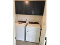 Bright laundry room with white washer and dryer, and dark brown cabinets at 2753 Piazza Madama St, Henderson, NV 89044