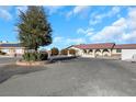 Front view of a ranch-style home with a large yard and circular driveway at 8870 W Craig Rd, Las Vegas, NV 89129