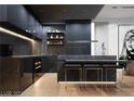 Modern kitchen with dark cabinetry, marble countertops, and bar seating at 924 S First St # 406, Las Vegas, NV 89101
