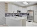Modern kitchen with white cabinets, quartz countertops, and stainless steel appliances at 1474 Fieldbrook St, Henderson, NV 89052