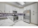 Updated kitchen featuring white cabinets, stainless steel appliances, and quartz countertops at 1474 Fieldbrook St, Henderson, NV 89052