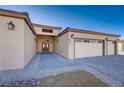 Front entry of home with two-car garage and walkway at 2140 Upland Ave, Pahrump, NV 89048
