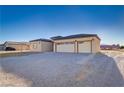 Lovely single-story home featuring a three-car garage, desert landscaping, and a paved driveway at 2140 Upland Ave, Pahrump, NV 89048