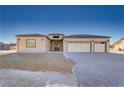 Welcoming home showcasing a three-car garage, modern design elements, and desert-friendly landscaping for curb appeal at 2140 Upland Ave, Pahrump, NV 89048