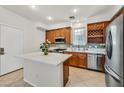 Modern kitchen with wood cabinets, stainless steel appliances, and island at 4356 Hera Temple Ave, North Las Vegas, NV 89031