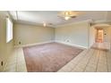 Spacious living room featuring tile flooring, plush carpeting, and modern ceiling fans that enhance the space at 458 Crestway Rd, Henderson, NV 89015