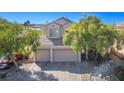 Two-story house with three-car garage and mature trees at 1033 Logan Patrick Dr, Henderson, NV 89052