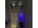 View of the front door, decorated windows and chandelier in a light grey entryway at 10997 Sardinia Sands Dr, Las Vegas, NV 89141