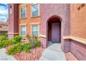 Residential building entryway with purple door and nicely landscaped entry at 3975 N Hualapai Way # 267, Las Vegas, NV 89129