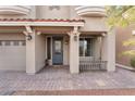 Close-up of the entrance of a two-story home featuring columns and a brick driveway at 10529 Parthenon St, Las Vegas, NV 89183