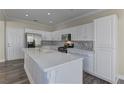 Modern kitchen with white cabinets and large island at 1067 Garden Cress Ct, Las Vegas, NV 89138