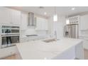 Modern kitchen with white cabinets, stainless steel appliances, and marble countertops at 10718 Glowing Dawn Ave, Las Vegas, NV 89135