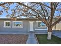 Front view of a single story home with tree at 1605 Oakwood Ave, North Las Vegas, NV 89030