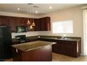 Kitchen with island, granite countertops, and dark wood cabinets at 3309 Conterra Park Ave, North Las Vegas, NV 89081