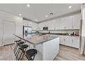 Spacious kitchen showcasing white cabinets, stainless steel appliances, and an expansive island with bar stool seating at 43 Strada Loreto, Henderson, NV 89011