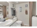 Small bathroom with toilet, sink, and laundry at 451 Sellers Pl, Henderson, NV 89011