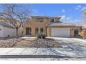 Two-story house with a tan exterior, green door and a two-car garage at 5313 Dawn Break Canyon St, North Las Vegas, NV 89031