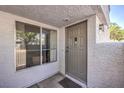 Home entry features a gray front door, side window, light fixture, and neutral stucco at 5655 Vineyard Ln # 0, Las Vegas, NV 89110