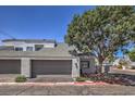 Home exterior featuring a two car garage, neutral stucco and desert landscaping at 5655 Vineyard Ln # 0, Las Vegas, NV 89110