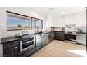 Modern kitchen with dark cabinetry, quartz countertops, and stainless steel appliances at 602 Calcutta Ln, Henderson, NV 89015