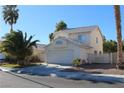 Two-story house with a white exterior, attached garage, and palm trees at 6113 Breeders Cup St, Las Vegas, NV 89130