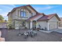 Two-story house with Spanish tile roof, mature trees, and decorative yard ornaments at 6233 Morning Splendor Way, Las Vegas, NV 89110