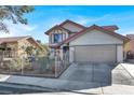 Two-story house with Spanish tile roof, wrought iron fence, and attached two-car garage at 6233 Morning Splendor Way, Las Vegas, NV 89110