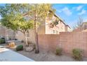 Side view of house with block wall and mature tree at 6255 W Arby Ave # 218, Las Vegas, NV 89118