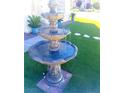 Three-tiered fountain in a front yard with artificial turf at 7629 Delaware Bay Dr, Las Vegas, NV 89128