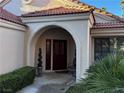 Covered entryway with arched entry and terracotta tile roof at 7732 Tinted Mesa Ct, Las Vegas, NV 89149