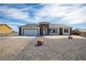 Inviting single-story home showcasing a two-car garage and drought-tolerant desert landscaping at 801 Fort Churchill Rd, Pahrump, NV 89060