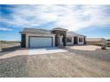 Attractive single-story home with a two-car garage, neutral colors, and desert landscaping at 801 Fort Churchill Rd, Pahrump, NV 89060