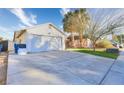 Exterior view of a house with an attached garage and a concrete driveway at 1574 Teardrop St, Las Vegas, NV 89142