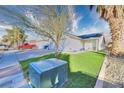 House exterior features a green lawn, solar panels, and a palm tree at 1574 Teardrop St, Las Vegas, NV 89142