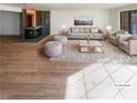 Virtually staged living room with fireplace and hardwood floors at 2386 Pickwick Dr, Henderson, NV 89014