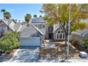 Two-story house with a gray exterior, solar panels, and landscaped yard at 2632 Cathedral Ln, Las Vegas, NV 89108