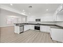 Modern kitchen featuring white cabinets, dark countertops, and stainless steel appliances at 2812 Dotted Wren Ave, North Las Vegas, NV 89084