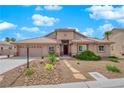 Single-story house with a tan exterior, a three-car garage, and landscaped front yard at 319 Hidden Highlands Dr, Las Vegas, NV 89110